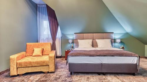 a bedroom with a bed and a chair at St Lukas Medical & SPA in Świeradów-Zdrój