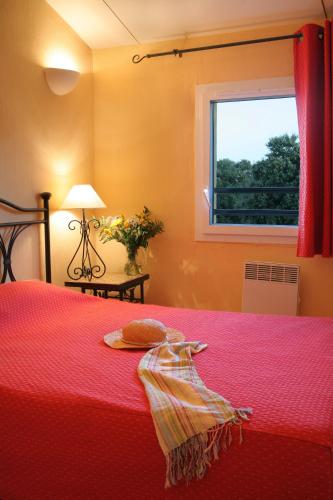 - une chambre avec un lit rouge et une fenêtre dans l'établissement Résidence Néméa les Portes des Cévennes, à Sauve