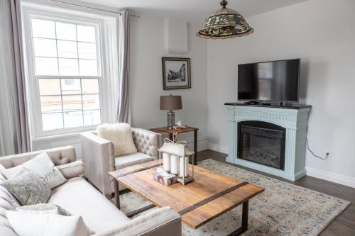 a living room with a couch and a fireplace at Modern Apt Near Downtown Burlington Ideal for long stays - U2 - The Blair in Burlington