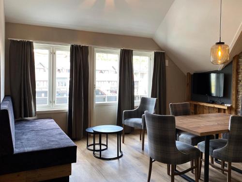 バイトストーレンにあるGjestegaarden Leiligheterのダイニングテーブルと椅子のあるリビングルーム