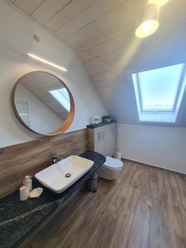 W łazience znajduje się umywalka, lustro i toaleta. w obiekcie MILOCHÓWKA - dom drewniany bliźniak w mieście Wdzydze Tucholskie