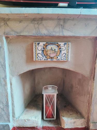 a fireplace with a plate and a red candle at CASA DUCHESSE al Castello in Ferrara