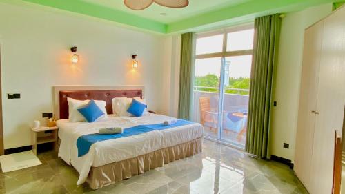 a bedroom with a bed and a large window at Alimas Holiday Retreat Maldives in Felidhoo