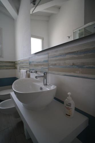 a white bathroom with a sink and a mirror at Villa Lentischio in Budoni
