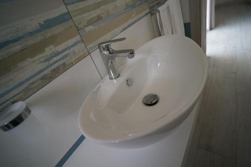 a white sink in a bathroom next to a mirror at Villa Lentischio in Budoni