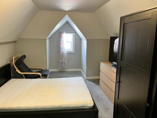 a bedroom with a bed and a tv and a window at Guest House in Winnipeg