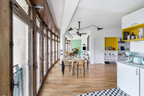 une cuisine et une salle à manger avec une table et des chaises dans l'établissement THE BUILDING - Appartement d'architecte avec vue Notre Dame de la Garde, à Marseille