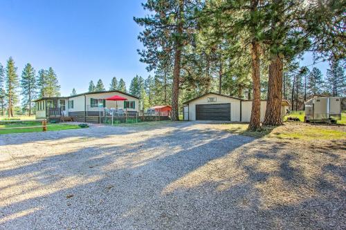 a home with a garage and a house with trees at Cozy Chiloquin Retreat Less Than 30 Mi to Crater Lake! in Chiloquin