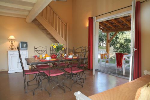 a dining room with a table and chairs and a patio at Résidence Néméa les Portes des Cévennes in Sauve