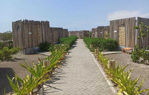 a walkway in a garden with wooden fences at Solé Paracas in Paracas