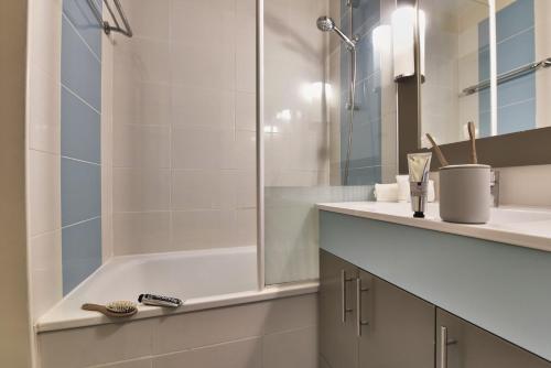 a bathroom with a shower and a sink and a tub at Résidence Pierre & Vacances Ty Mat in Saint Malo