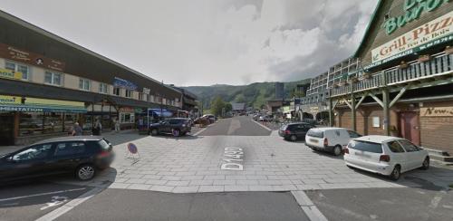una calle de la ciudad con coches aparcados en la calle en Superbesse - 300m pistes & lac - App 6 pers, en Besse-et-Saint-Anastaise
