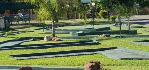 a park with rocks and palm trees in the grass at Pendleberry Holiday Resort - Unit 40 in Bela-Bela
