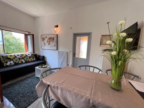 salon ze stołem i wazą kwiatów w obiekcie Apartments Valentinovo w mieście Klenovica