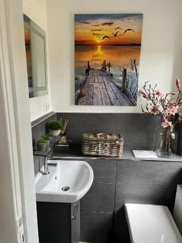 La salle de bains est pourvue d'un lavabo et d'une photo de la jetée. dans l'établissement Haus Frida, à Barth