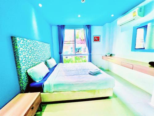 a blue room with a bed and a window at Atlantis Condo Resort GP in Jomtien Beach