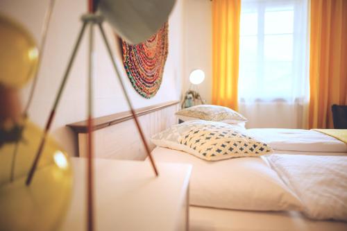 a bedroom with two beds and a window at Das Hotel Stern, B&B KG - digital & contactless check-in in Sankt Gilgen