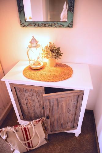 a white table with a mirror and a plant on it at Das Hotel Stern, B&B KG - digital & contactless check-in in Sankt Gilgen