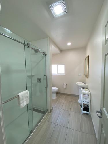 a bathroom with a glass shower and a toilet at Salt Air Lodge in Santa Cruz