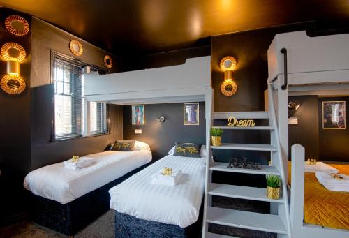 切斯特的住宿－The Lombard House - Sleeps Up To 12，带两张双层床和楼梯的客房