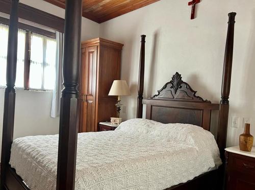 a bedroom with a large bed with a wooden frame at Hotel La Casa de las Sirenas in Tlacotalpan