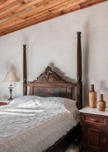 a bedroom with a bed with a wooden head board at Hotel La Casa de las Sirenas in Tlacotalpan