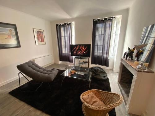 a living room with a fireplace and a television at Studio Plein Centre in Rambouillet