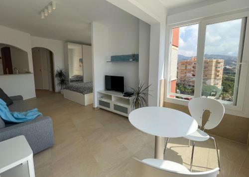 a living room with a couch and a table and chairs at Studio Carabela in Torrox