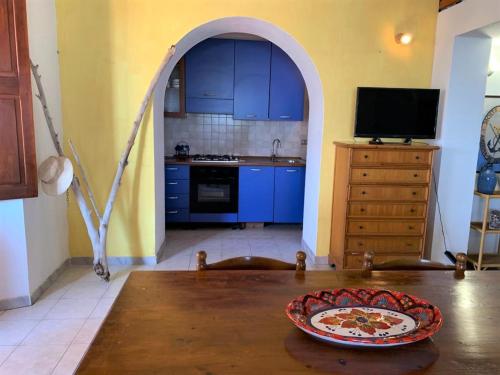 a kitchen with blue cabinets and a table with a plate on it at Le case sul lido di Lingua - Isola Salina in Lingua