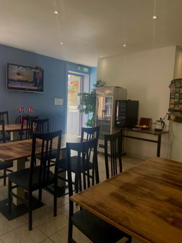 une salle à manger avec des tables et des chaises dans un restaurant dans l'établissement Hôtel du Cerf, à La Guerche-sur-lʼAubois