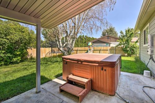 a hot tub sitting under a porch with a bench at Lovely Twin Falls Home with Private Hot Tub! in Twin Falls
