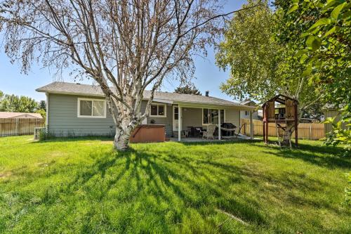 a house with a tree in the yard at Lovely Twin Falls Home with Private Hot Tub! in Twin Falls