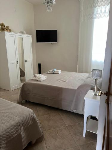 a bedroom with a bed and a tv on the wall at Casa Lucy in Ercolano