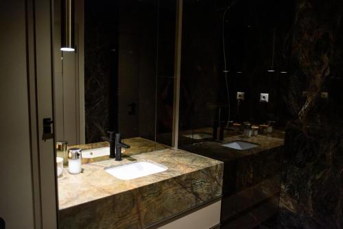 a bathroom with two sinks and a large mirror at Opera Apartments in Cluj-Napoca