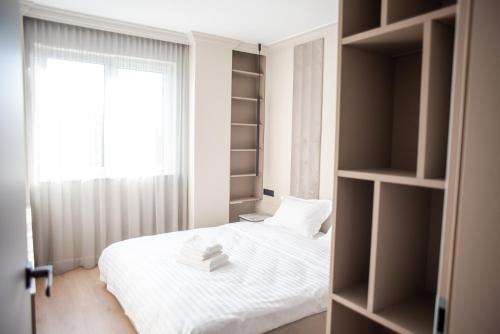 a bedroom with a white bed and a window at Opera Apartments in Cluj-Napoca