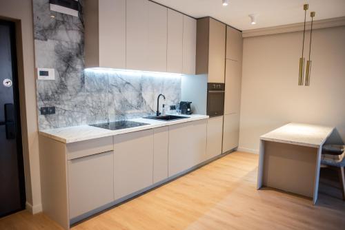a kitchen with white cabinets and a sink and a counter at Opera Apartments in Cluj-Napoca
