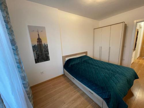 a bedroom with a bed with a green comforter at Fantastic centar Novi Sad in Novi Sad