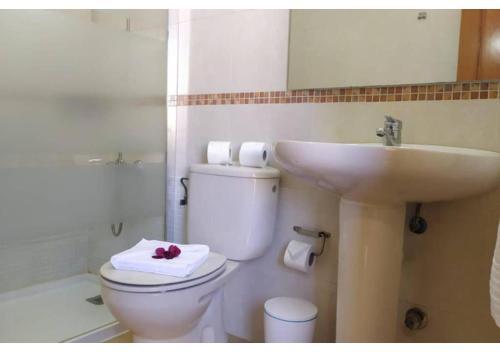 uma casa de banho com um WC branco e um lavatório. em Anahi Homes Corralejo- Villa Dracacena 14 em La Oliva