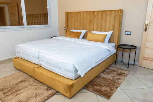 een slaapkamer met een groot bed met een houten hoofdeinde bij Résidence Amal in Dakhla