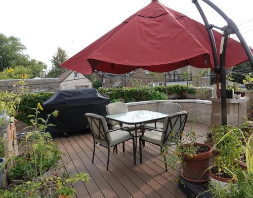 a patio with a table and chairs and an umbrella at Ray's Bucktown Bed and Breakfast in Chicago