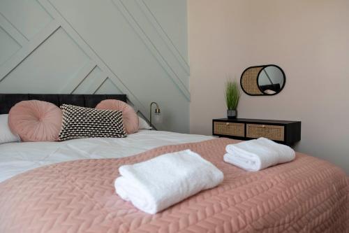 a bedroom with a pink bed with two towels on it at The Callie by Sasco Apartments in Blackpool
