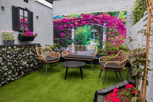 a patio with chairs and a table and flowers at The Callie by Sasco Apartments in Blackpool