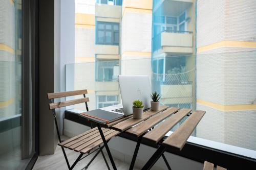 a wooden table with a laptop on a balcony at Famara Suites by AirNest in Las Palmas de Gran Canaria