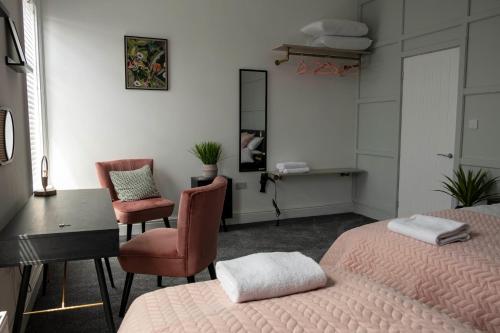 a bedroom with two beds and a desk and a mirror at The Callie by Sasco Apartments in Blackpool