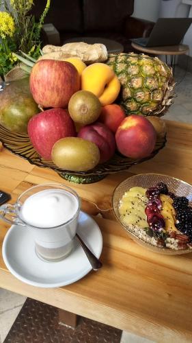 a basket of fruit on a table with a cup of coffee at OPUNTIA Hotel Boutique in Mijas