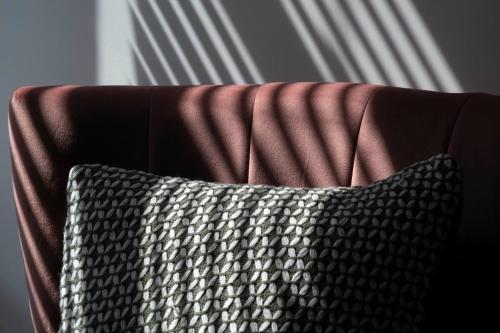 a brown couch with a black and white pillow at The Callie by Sasco Apartments in Blackpool