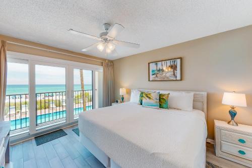 a bedroom with a bed and a balcony with the ocean at Huntington by the Sea 201 Miramar Beach (Condo) in Destin