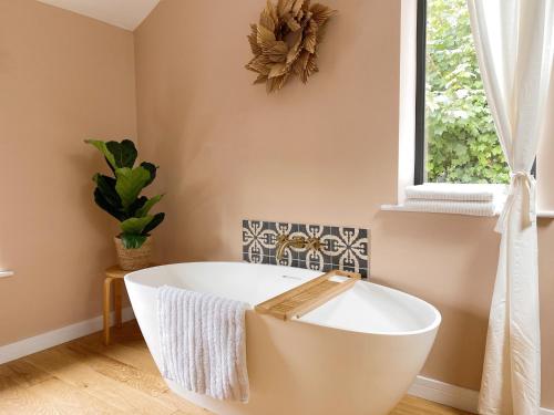 a bath tub in a bathroom with a window at Luxury bolthole in central St.Agnes with parking. in St. Agnes