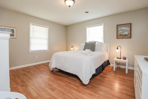 a bedroom with a large white bed and two windows at Spacious Home with Waterfront View-Welcome Pets in Sneads Ferry