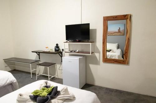 Habitación con cama, espejo y escritorio. en Olienhoff Guesthouse en Otavi